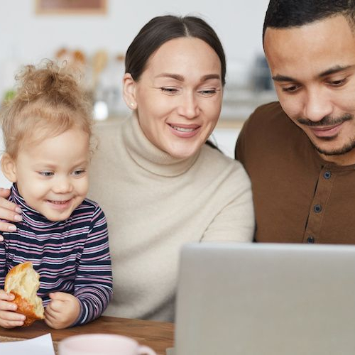 A young family at a kitchen table, possibly discussing household matters or finances.