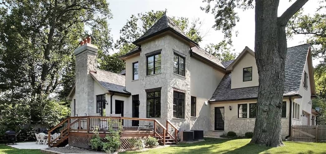 A grand house with a huge yard and deck.