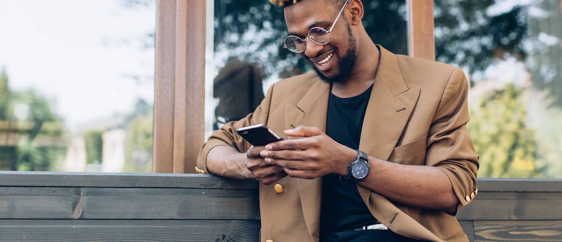 A businessman in a suit focused on his smartphone, multitasking in a modern world.