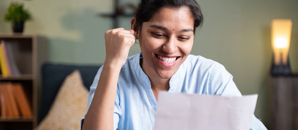 Young woman overjoyed to receive college acceptance letter.