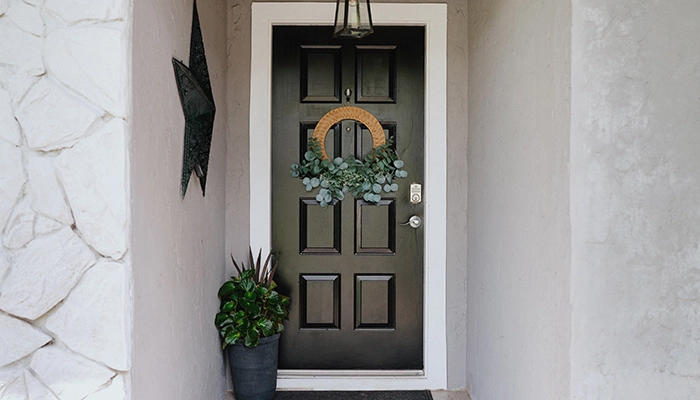 Grey house with stone features and black door.