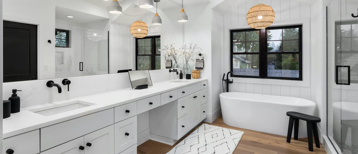 Bathroom mid-renovation with new white tile and dark wood vanity.