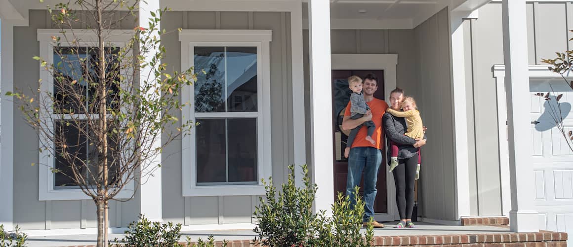 RHB Assets From IGX: Family standing in front of their new home, smiling