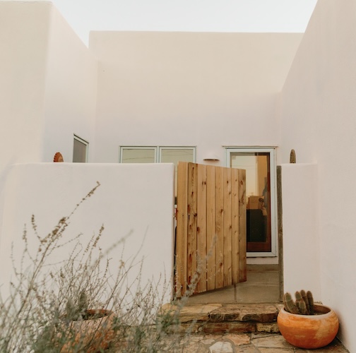 Doorway to front porch of home in Marfa, Texas, with potted cacti out front.