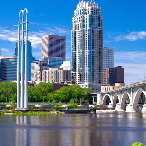 A first-time homebuyer smiling in front of a house.