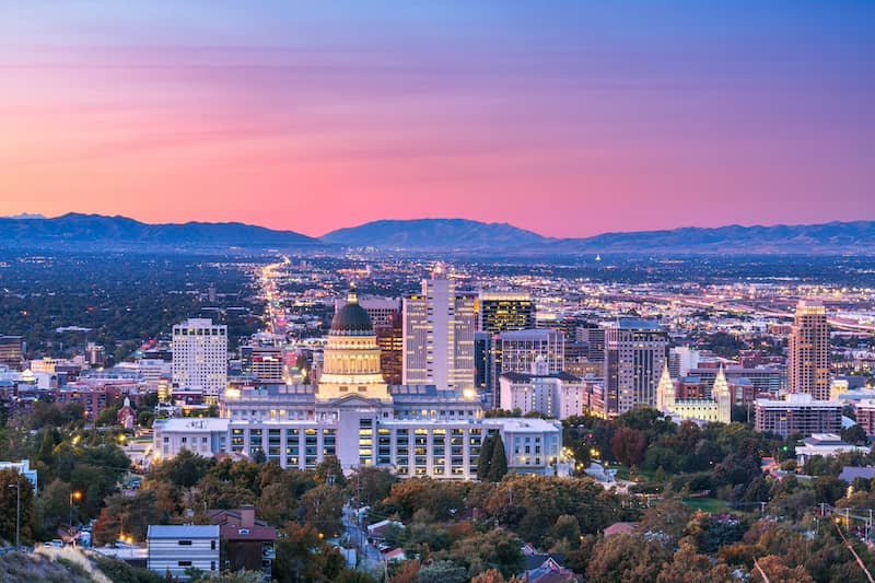 Salt Lake City seen from afar under a pink and blue sky.