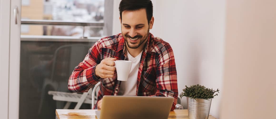 Stock-Man-In-Red-Flannel-Drinking-Coffee-At-Table-With-Computer-AdobeStock134261991 copy.jpg