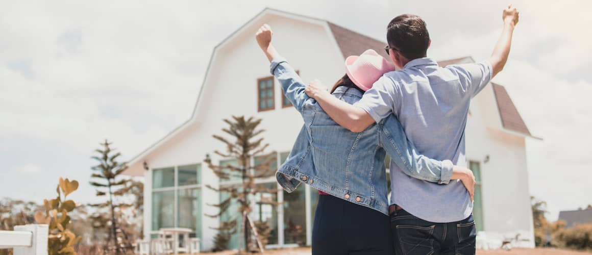 RHB Assets From IGX: Happy couple standing in front of their new home