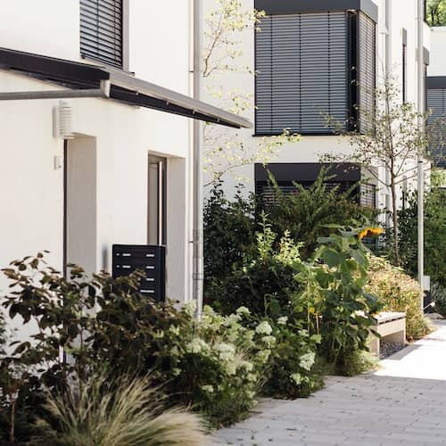 White modern multi unit townhomes with lush landscaping.