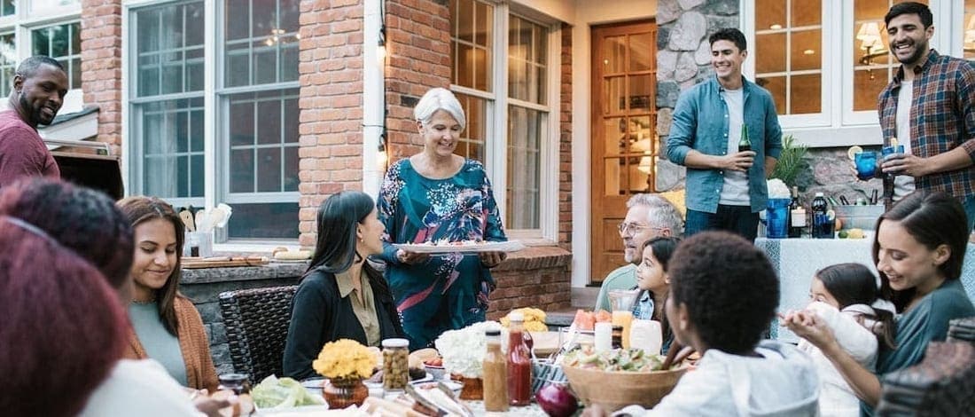 A family gathered around a table, eating and drinking together.