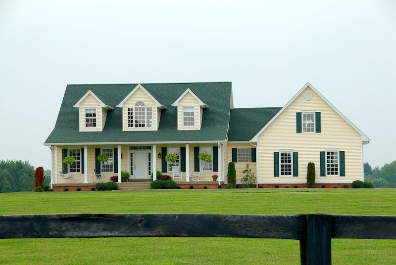 RHB Assets From IGX: Large farmhouse with a wraparound porch and green lawn.