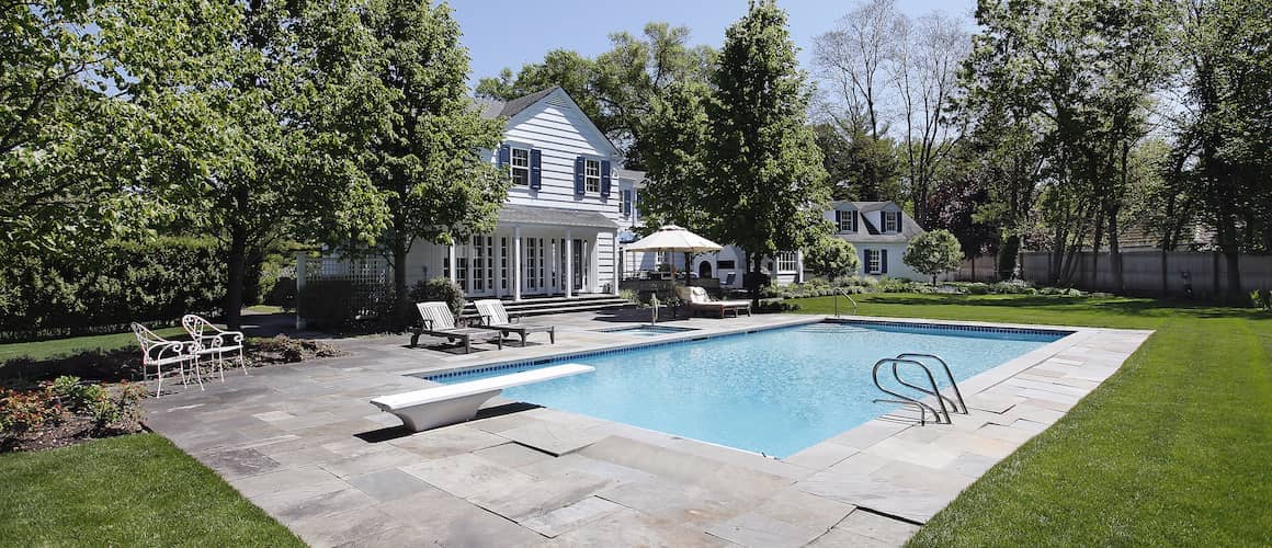 Backyard with in-ground pool and landscaping.