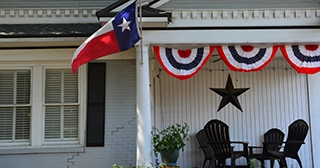 Photo of a home in Texas with a front porch, a Texas flat and a star on the house.