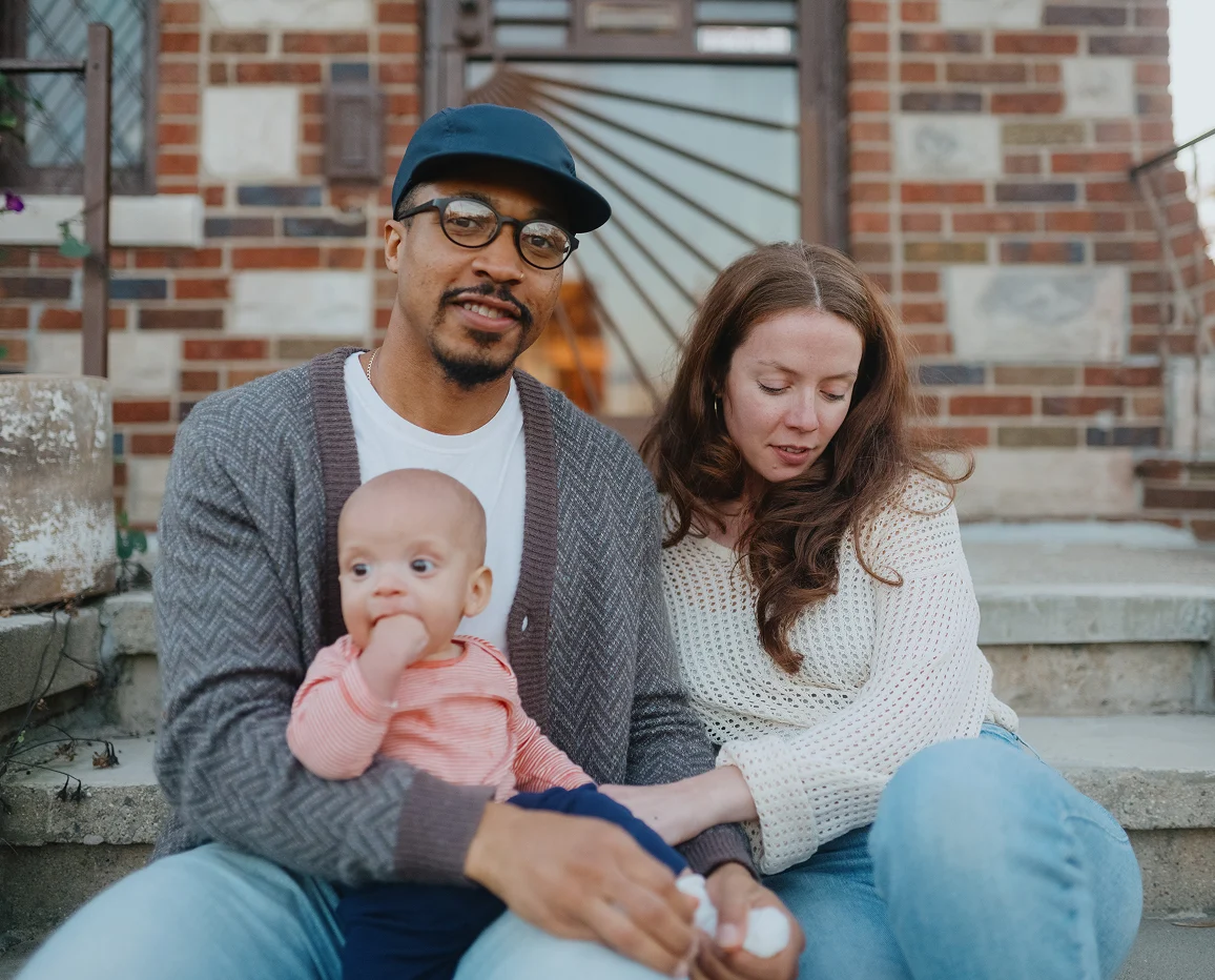Parents sitting on steps with their baby