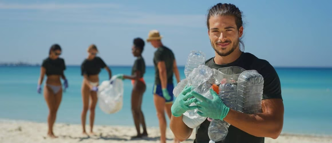 Group of people  on the beach collecting recyclables.