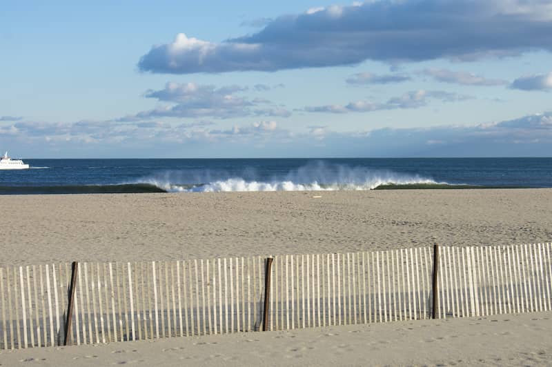 RHB Assets From IGX: Aerial view of Belmar beach with ocean waves and a sandy shoreline.