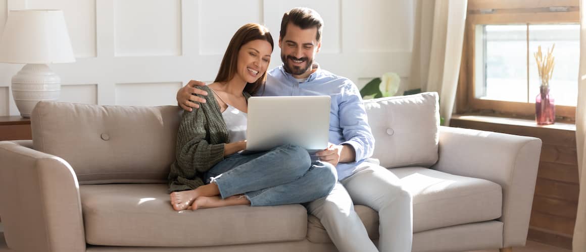 RHB Assets From IGX: Couple with a laptop on a couch