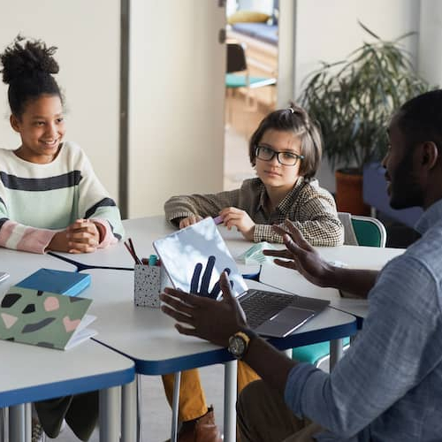 A teacher in a classroom benefiting from home loans.