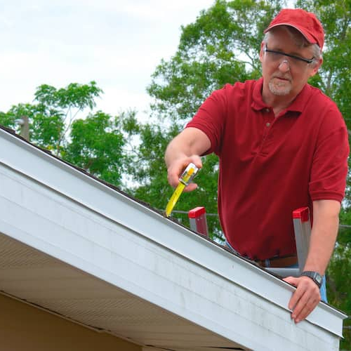 Home inspector on a roof performing an inspection.