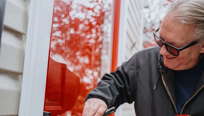 Man painting front door bright red.