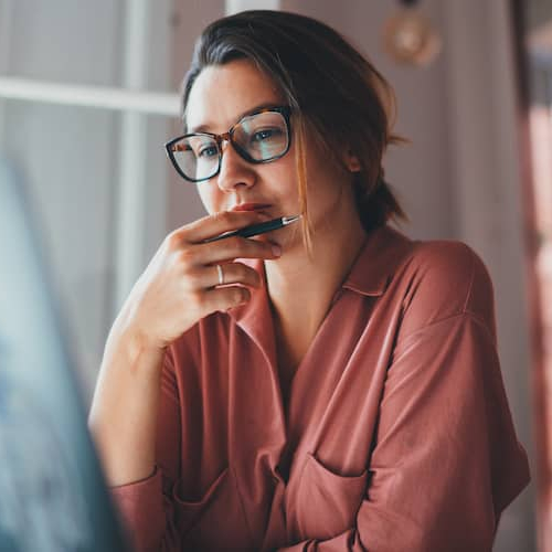 Image showing a young businesswoman contemplating while sitting in front of an open laptop.
