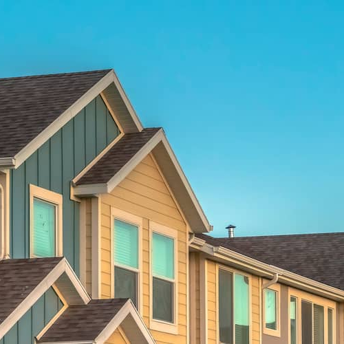 A woman hanging a series of photos on the wall.