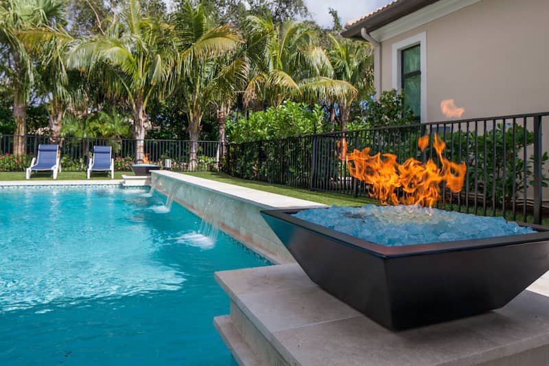 RHB Assets From IGX: Luxurious backyard pool with a fire pit and lounge chairs