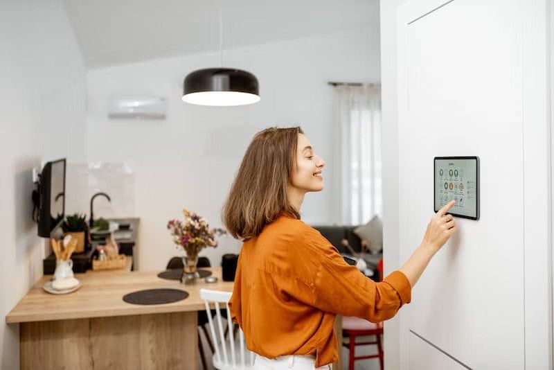 Woman entering code into home security smart screen.