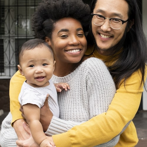 A family in front of a porch, depicting a home setting and family-oriented lifestyle.