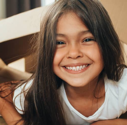 A girl playing with cardboard boxes during the unboxing of things possibly after shifting into a new home.