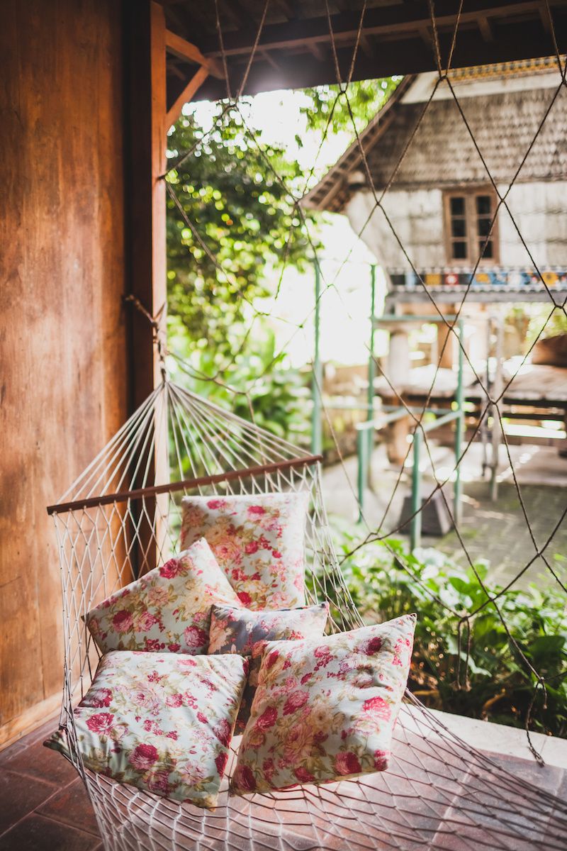 RHB Assets From IGX: Cozy hammock outside, surrounded by greenery and a wooden fence.