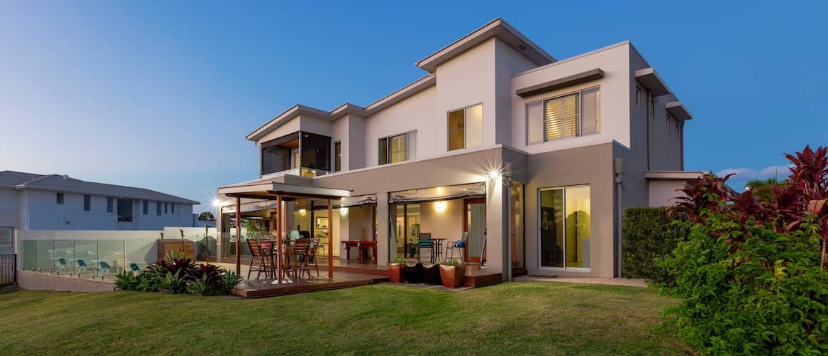 A large modern home with a pool outside.