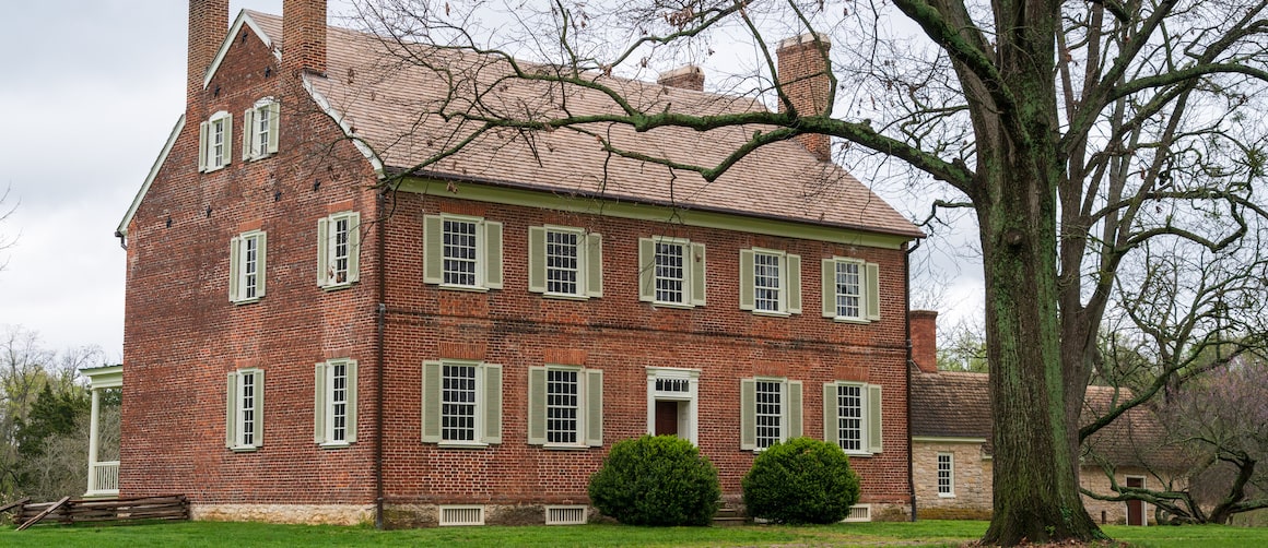 Brick colonial farmhouse, depicting a specific style of residential property.