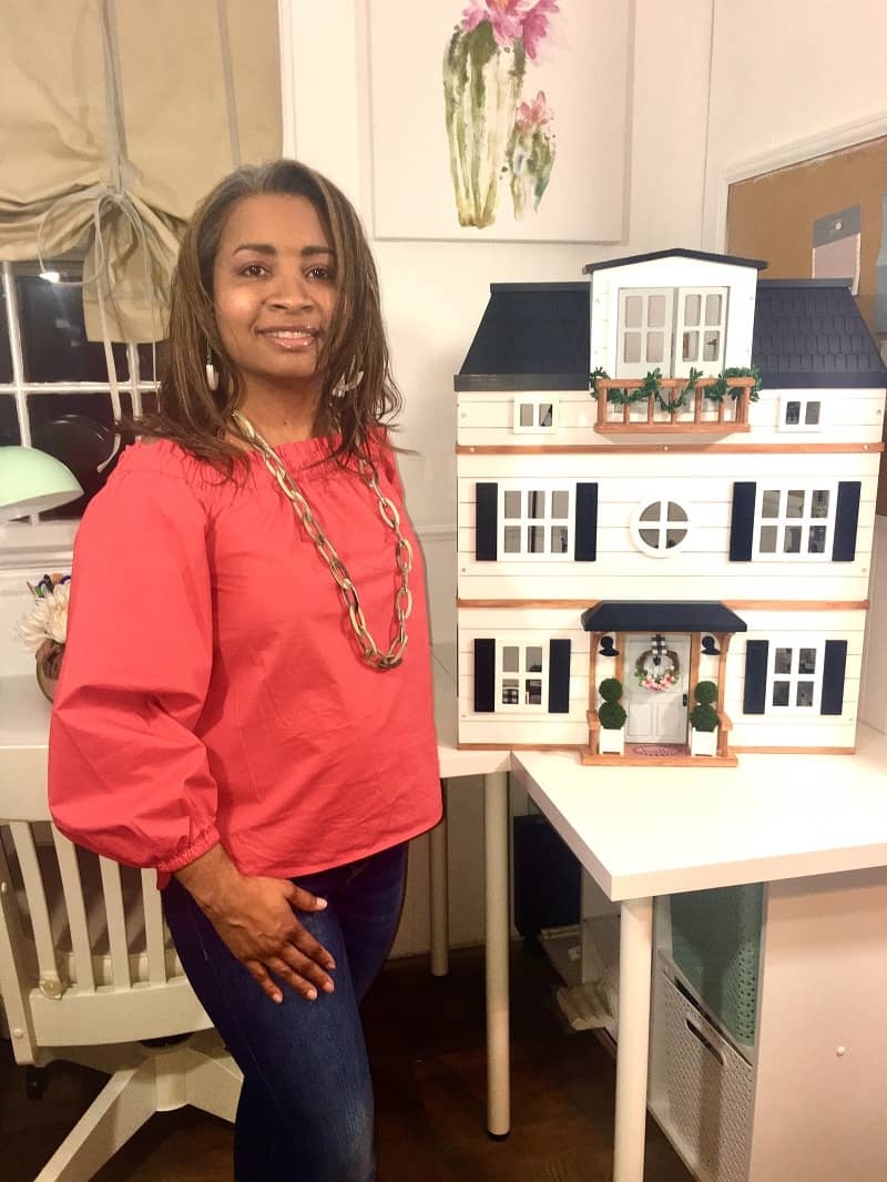 Dr. Kwandaa Roberts posing with her dollhouse that went viral.