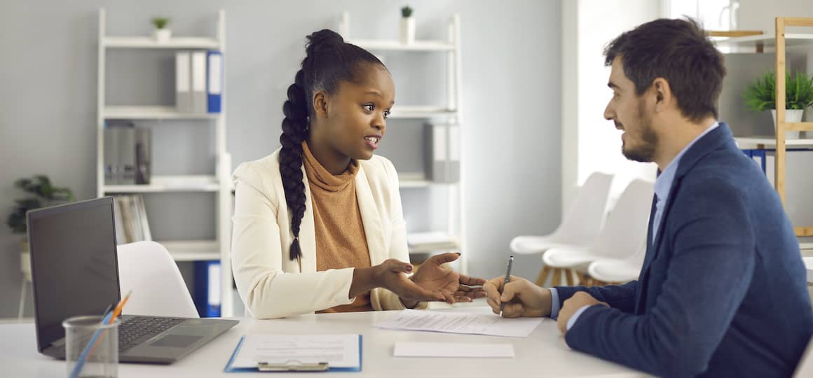 A man speaking to a financial advisor, potentially discussing financial planning related to real estate or homeownership.