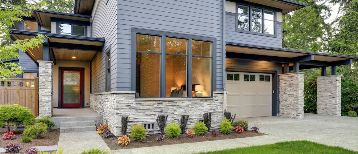 RHB Assets From IGX: Luxurious home exterior featuring stone veneer and large windows.