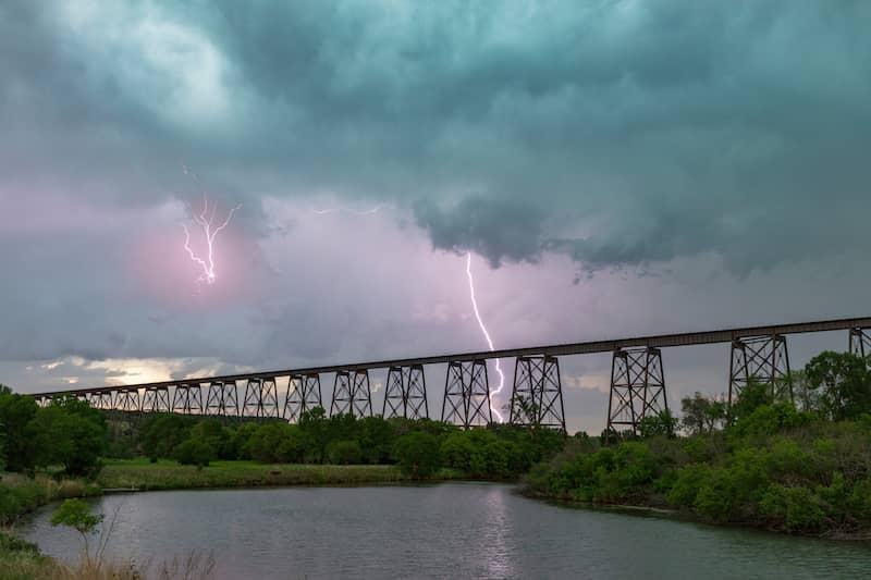 RHB Assets From IGX: Dramatic lightning over a bridge in Valley City, North Dakota, illuminating the sky and water.