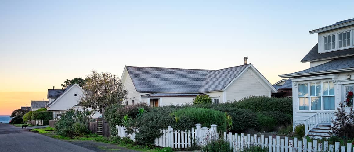A charming row of houses with a white picket fence, creating a picturesque neighborhood scene.