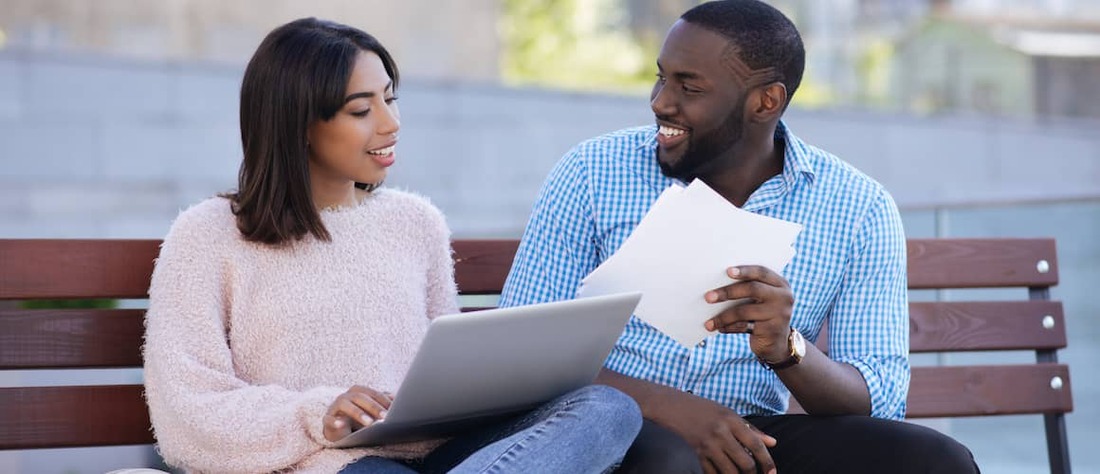 Stock-Black-Couple-On-Bench-With-Computer-And-Papers-AdobeStock159580149 copy.jpg