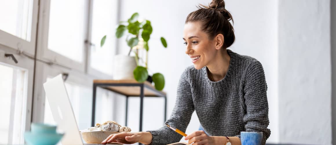 Image of woman smiling down at laptop screen.