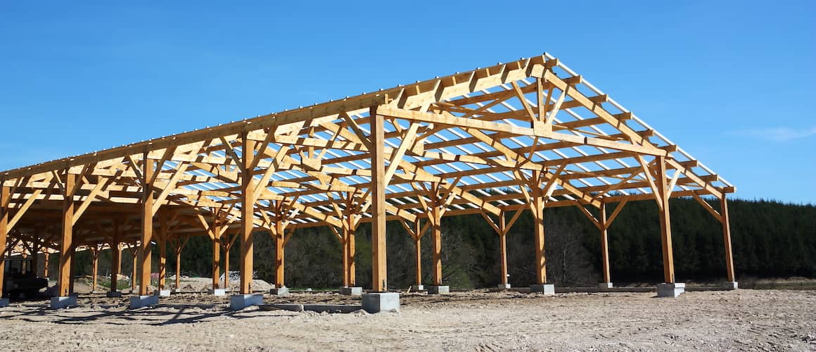 RHB Assets From IGX: Wooden barn being constructed in a rural area.