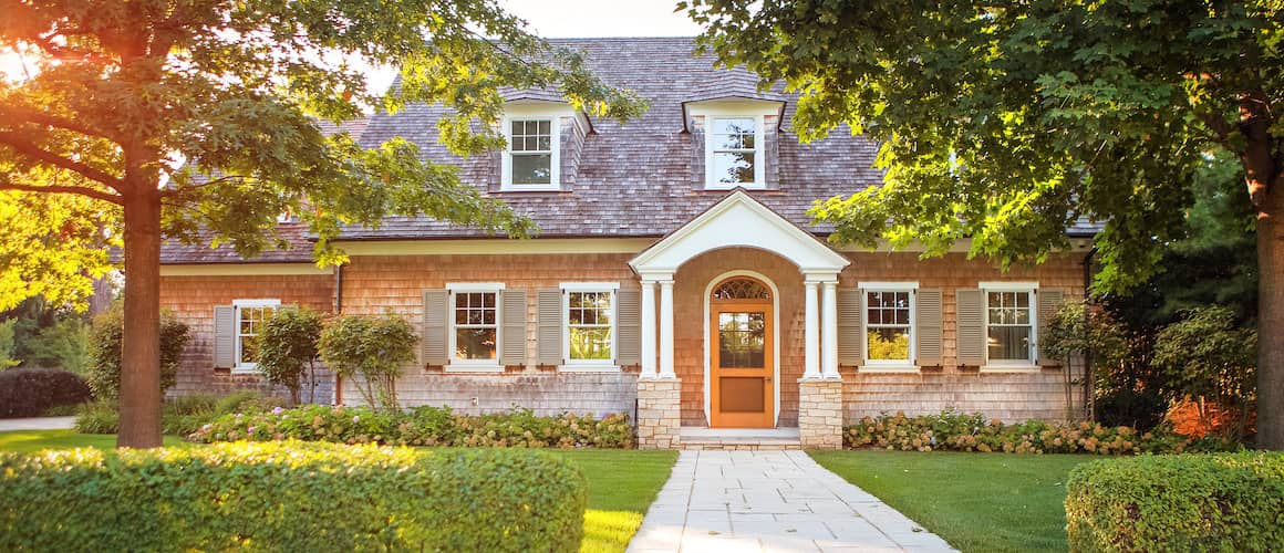 RHB Assets From IGX: Shingled house with white trim and lush landscaping