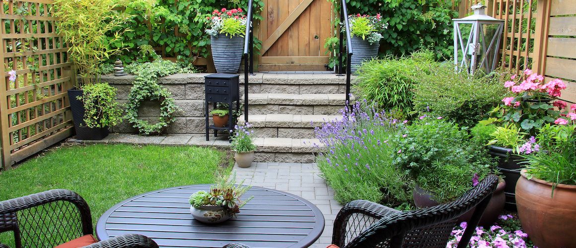 RHB Assets From IGX: Small and inviting backyard with a wooden deck and greenery.