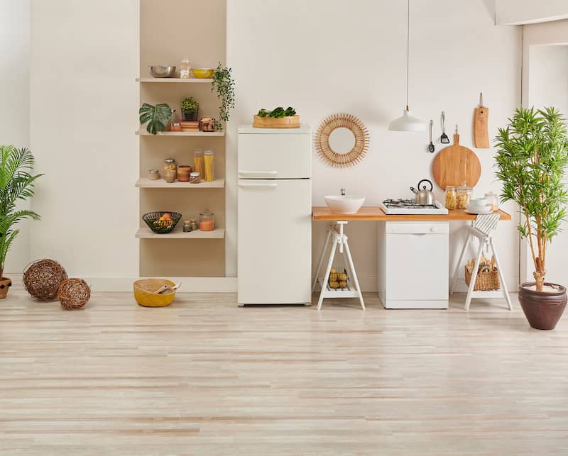 RHB Assets From IGX: Small rental kitchen featuring a large wall mirror, white cabinets, and wooden countertops.