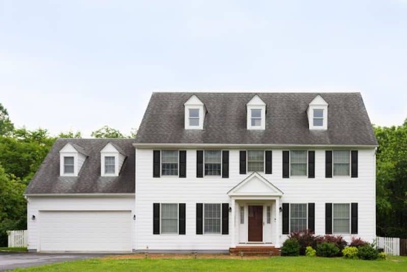 RHB Assets From IGX: Classic white American Colonial-style home with a landscaped yard.