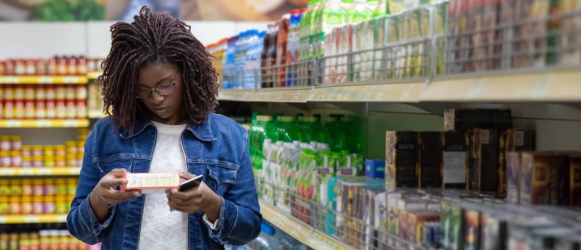 African American woman shopping in a grocery store aisle.