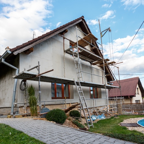 Construction platforms next to an old rural home for repairs.