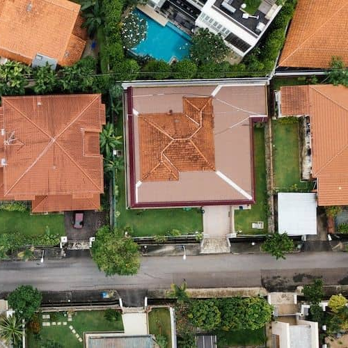 Aerial shot of a neighborhood, showcasing houses, streets, and community living.