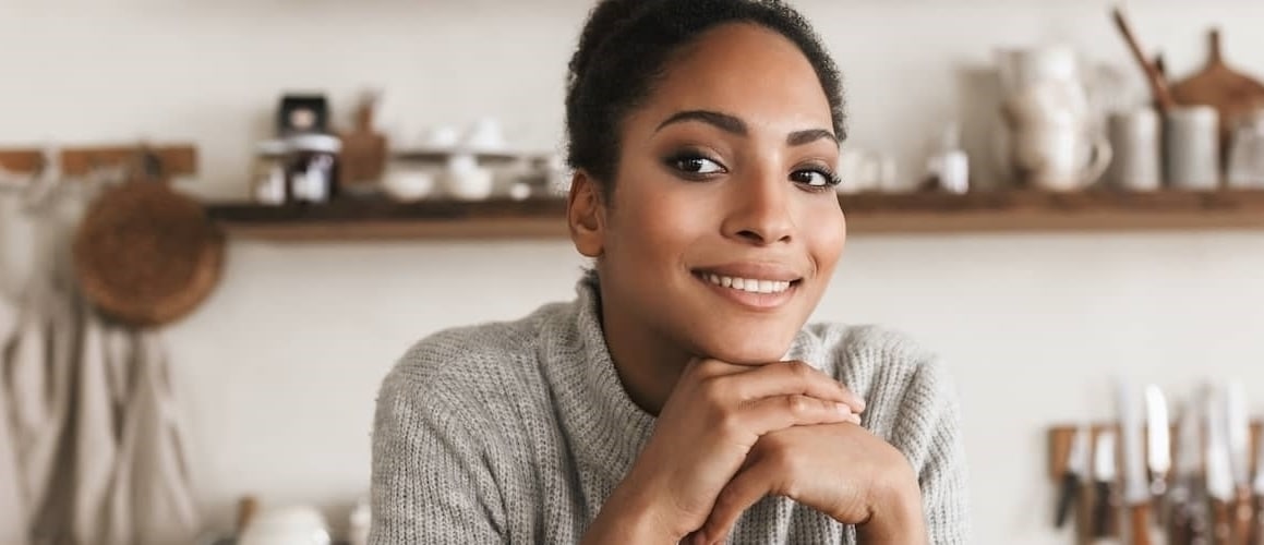 A woman smiling and thinking about something possibly an investment.