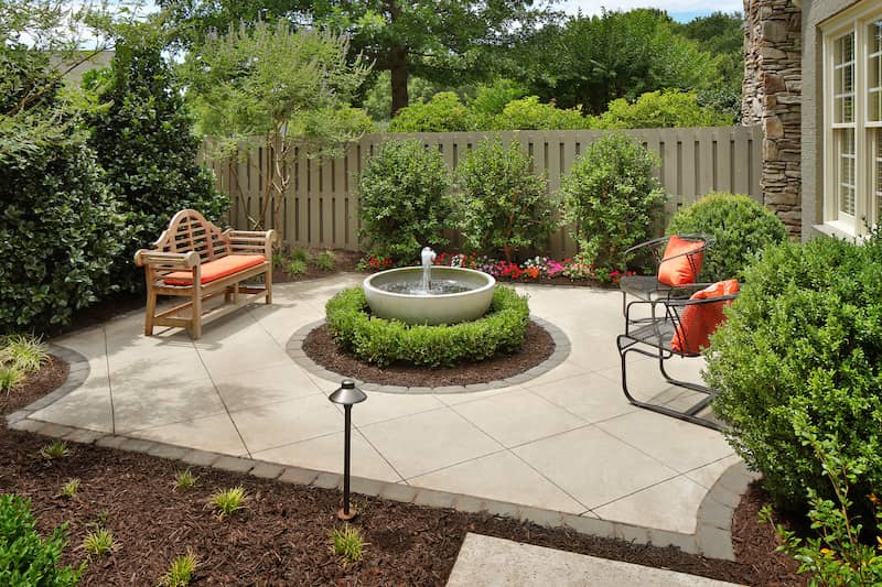 RHB Assets From IGX: Outdoor patio featuring a water fountain surrounded by plants and seating.